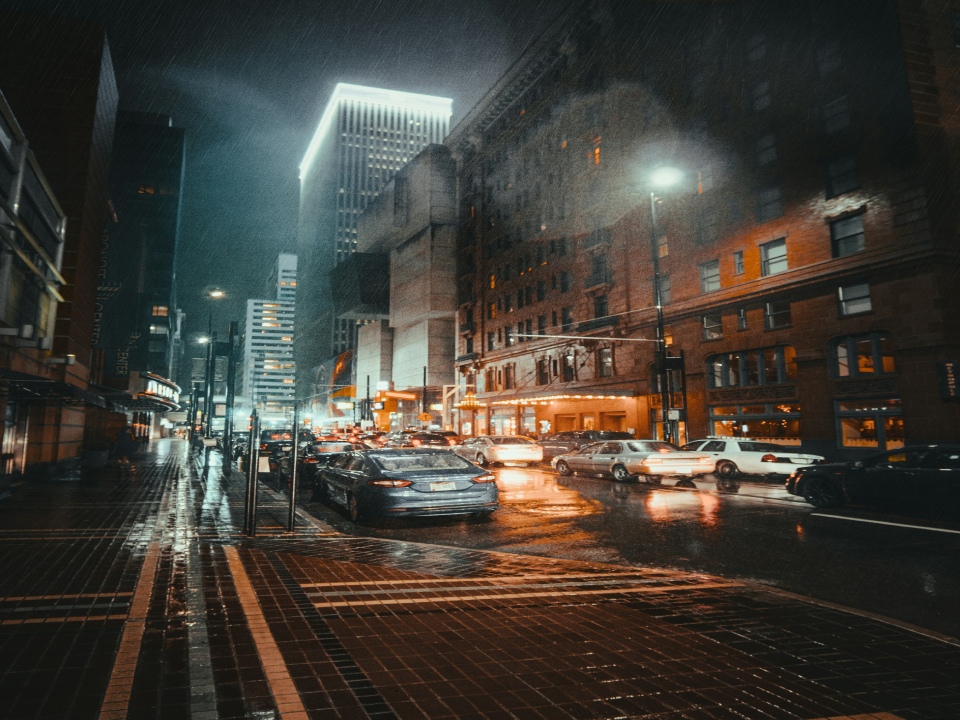 Cars driving along the road in the city at night